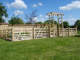 Chestnut gate hurdles around vegetable garden with arch and gate