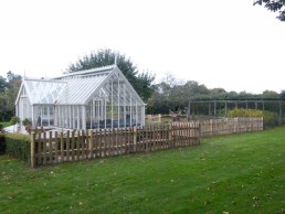 Cleft sweet chestnut paling fence around vegetable and flower garden