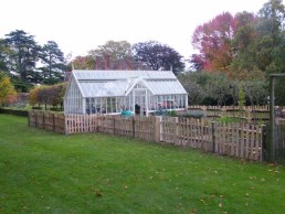 Cleft sweet chestnut paling fence around vegetable and flower garden