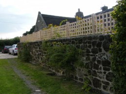 Cleft chestnut trellis along top of stone wall to give greater privacy from overlooking property
