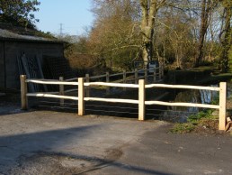 Cleft chestnut post and rail with twin galvanised wire below lower rail by mill leat 