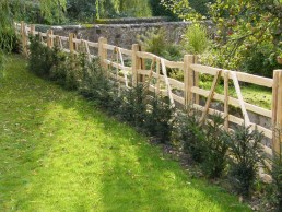 Sweet chestnut gate hurdles behind young yew hedge