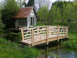 Oak and chestnut bridge over chalk stream